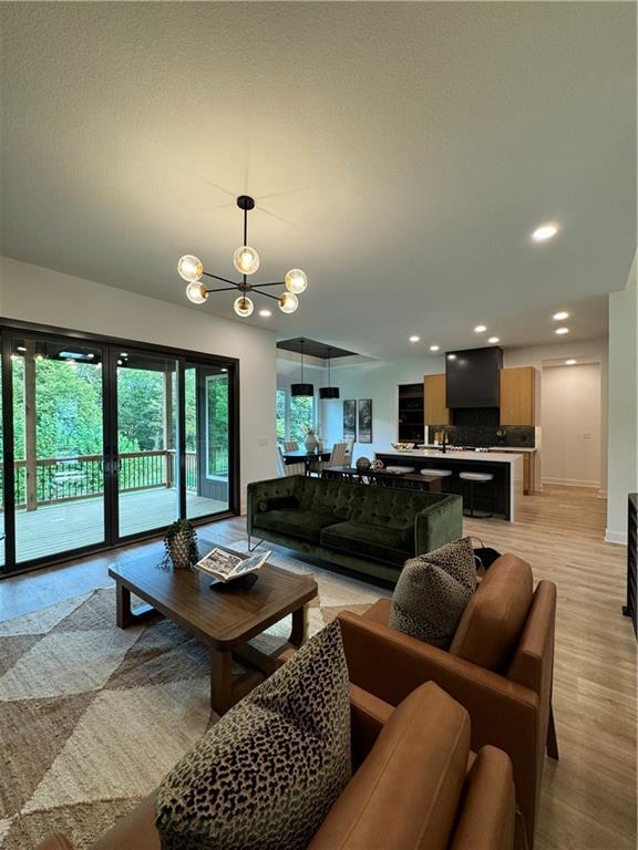 living room with light hardwood / wood-style floors and an inviting chandelier