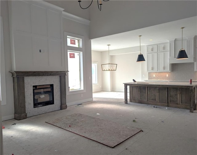 unfurnished living room featuring a chandelier