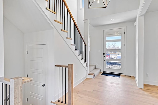 foyer with a towering ceiling and light hardwood / wood-style floors