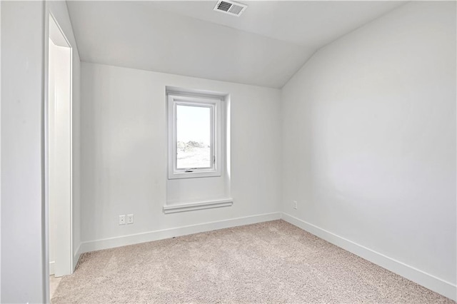 carpeted empty room with lofted ceiling