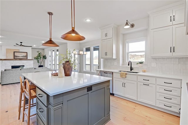 kitchen with pendant lighting, dishwasher, gray cabinetry, white cabinets, and a kitchen island