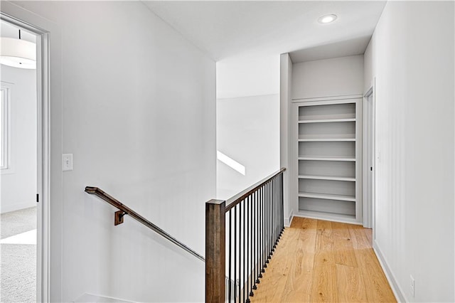 walk in closet with light hardwood / wood-style floors