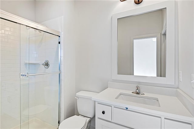 bathroom with vanity, a shower with shower door, and toilet