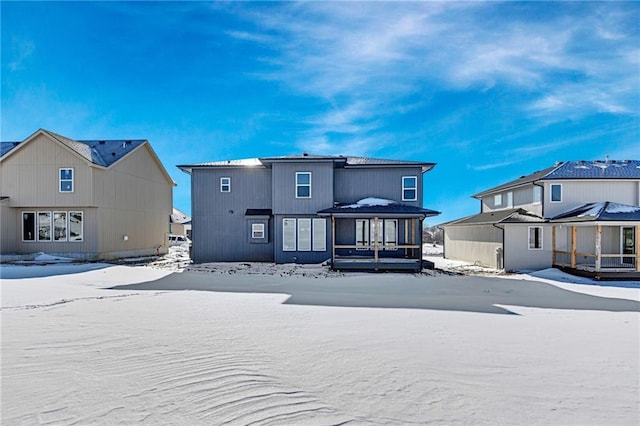 view of snow covered rear of property