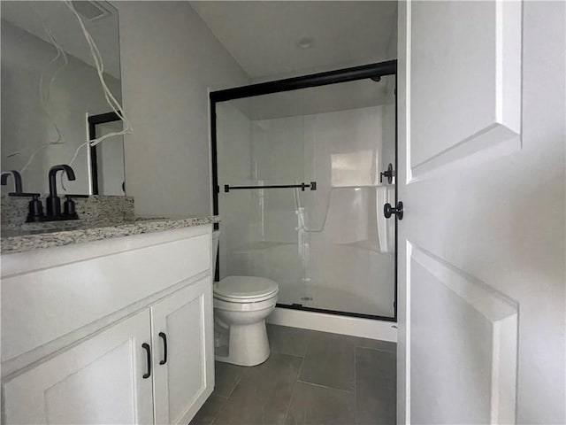 bathroom featuring vanity, an enclosed shower, and toilet