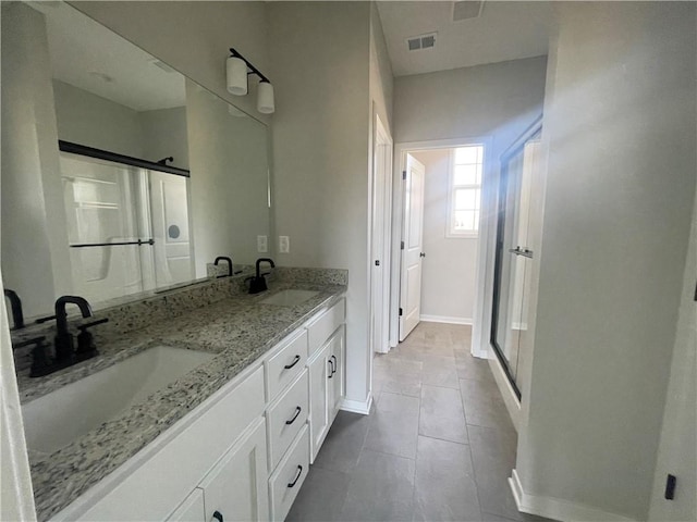 bathroom featuring vanity, tile patterned flooring, and walk in shower