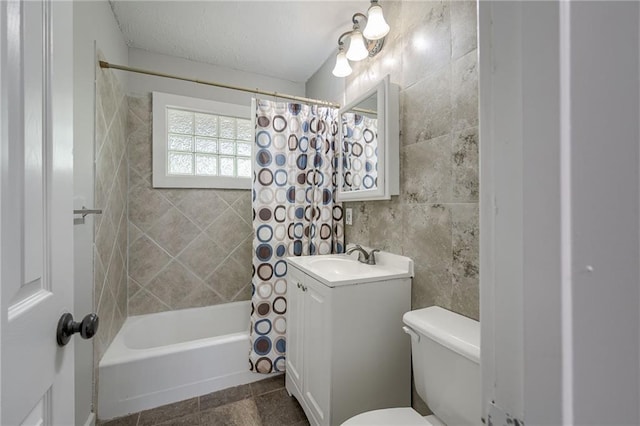 full bathroom featuring tile walls, vanity with extensive cabinet space, shower / bath combination with curtain, tile floors, and toilet