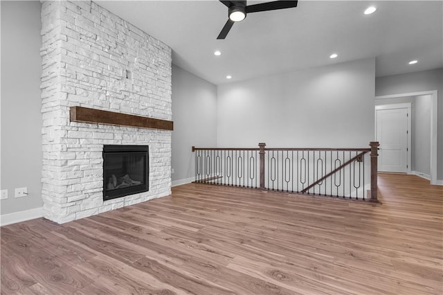 unfurnished living room with a fireplace, light wood-type flooring, and ceiling fan