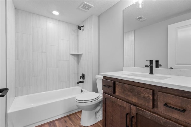 full bathroom with vanity, bathtub / shower combination, toilet, a textured ceiling, and wood-type flooring