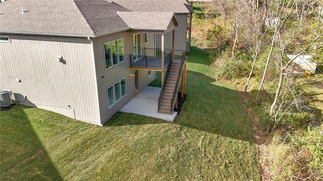 view of side of home with a lawn, central AC, a patio, and a deck