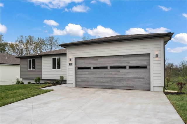 view of front facade with a front yard, driveway, and a garage