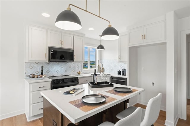 kitchen featuring a kitchen island, backsplash, dishwasher, white cabinetry, and black range with electric cooktop