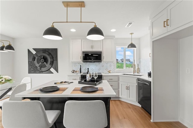 kitchen featuring decorative backsplash, visible vents, stainless steel appliances, light countertops, and light wood finished floors