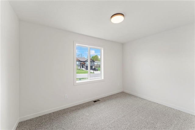 unfurnished room featuring carpet flooring, visible vents, and baseboards