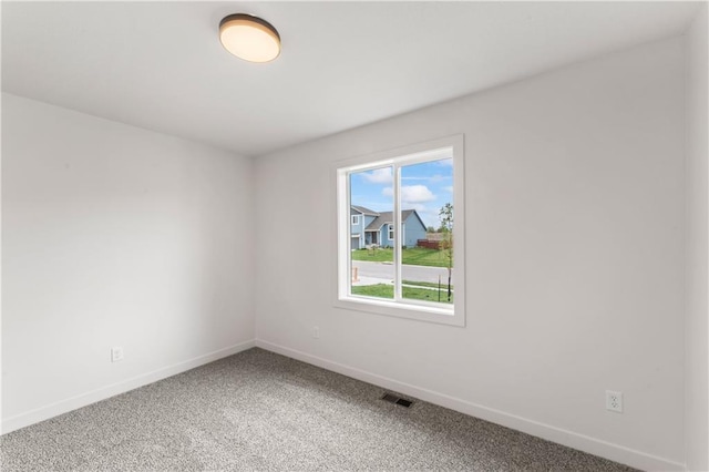 spare room featuring baseboards, visible vents, and light carpet