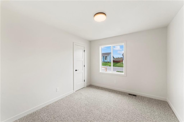 empty room with visible vents, light carpet, and baseboards