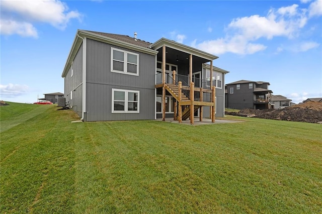 rear view of house featuring a sunroom and a yard