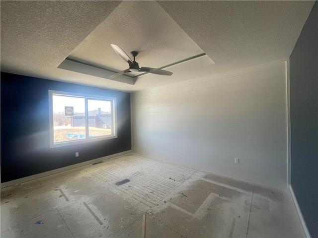 spare room featuring ceiling fan, a textured ceiling, and a raised ceiling