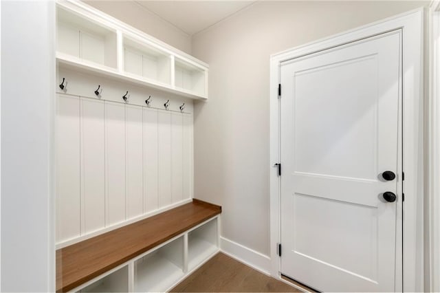 mudroom featuring dark wood-type flooring and baseboards