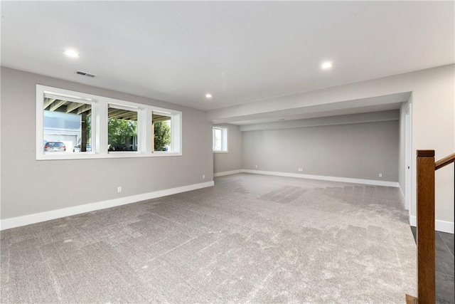 below grade area featuring baseboards, visible vents, stairway, carpet floors, and recessed lighting