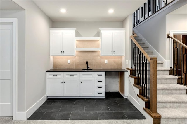 bar featuring baseboards, recessed lighting, a sink, and decorative backsplash