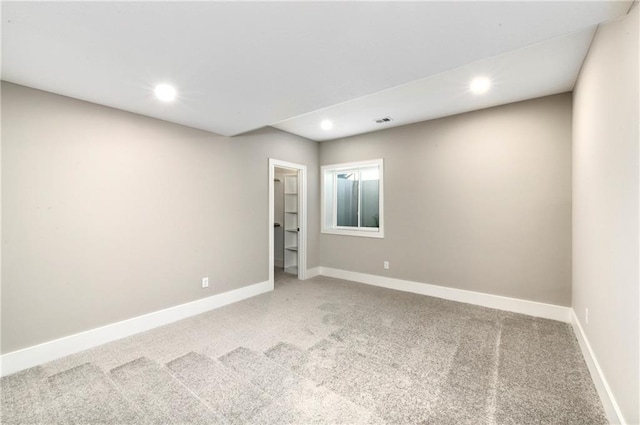 empty room with carpet floors, baseboards, and recessed lighting