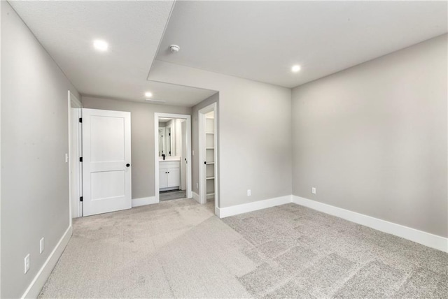 empty room featuring recessed lighting, light colored carpet, and baseboards