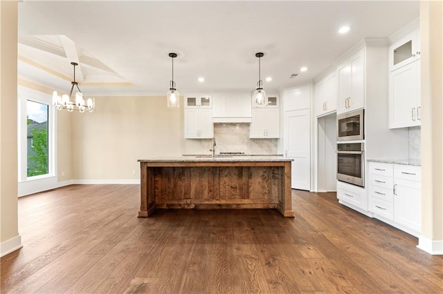 kitchen featuring a center island with sink, dark hardwood / wood-style flooring, appliances with stainless steel finishes, and white cabinetry