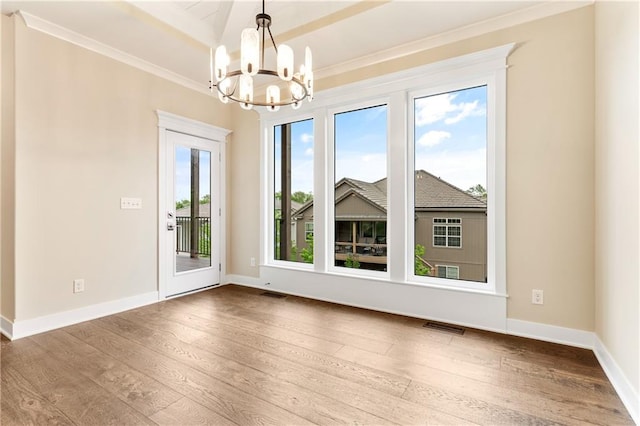 unfurnished room with hardwood / wood-style floors and an inviting chandelier