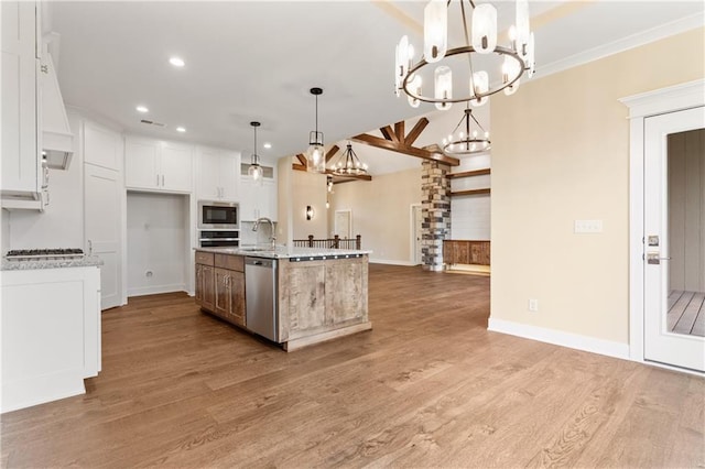 kitchen featuring decorative light fixtures, appliances with stainless steel finishes, wood-type flooring, an island with sink, and an inviting chandelier