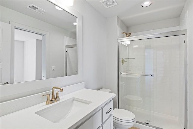 bathroom with a shower with door, vanity, and toilet