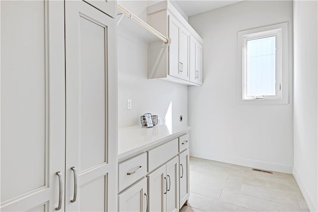 22051 W 100th Ter, Lenexa, KS 66220 - laundry area with baseboards, electric dryer hookup, and light tile patterned floors