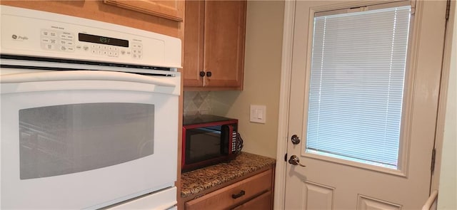 kitchen with white oven and dark stone countertops