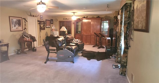 exercise area featuring light carpet and ceiling fan