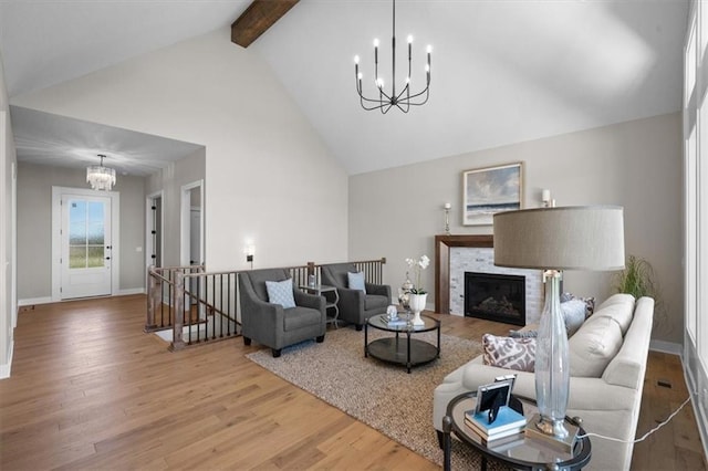 living room featuring an inviting chandelier, hardwood / wood-style flooring, beam ceiling, and high vaulted ceiling