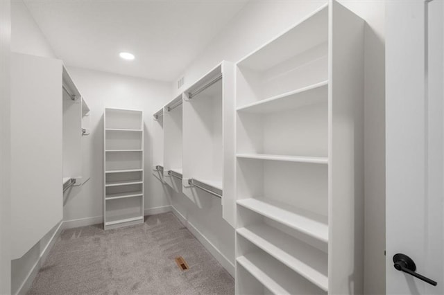 walk in closet featuring light colored carpet