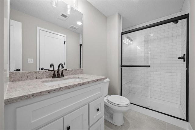 bathroom featuring vanity, tile patterned floors, toilet, and walk in shower