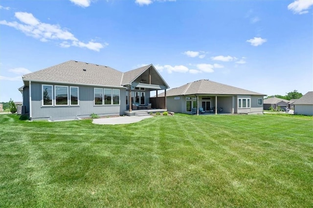 back of house featuring a lawn and a patio area