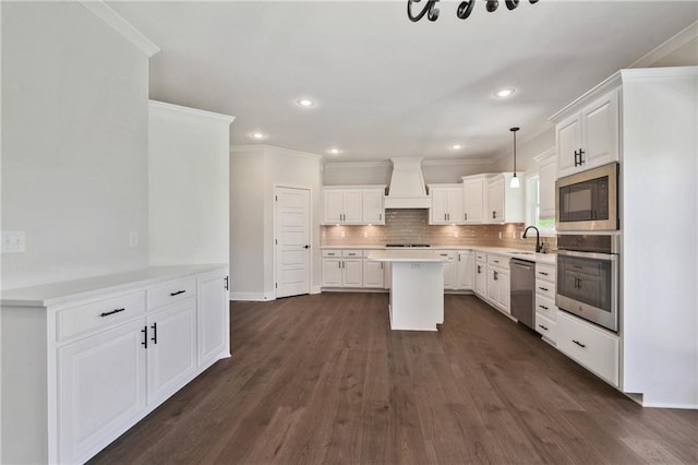 kitchen featuring backsplash, premium range hood, dark hardwood / wood-style flooring, white cabinets, and appliances with stainless steel finishes