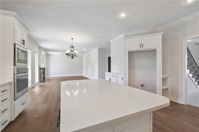 kitchen featuring pendant lighting, white cabinetry, oven, and wood-type flooring