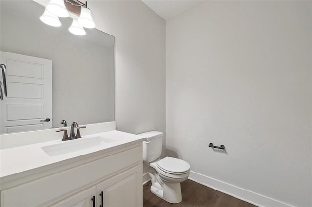 bathroom featuring hardwood / wood-style flooring, toilet, and vanity