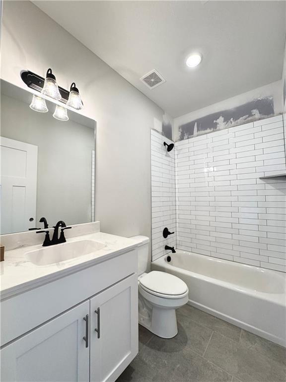 full bathroom with vanity, tile patterned flooring, tiled shower / bath combo, and toilet