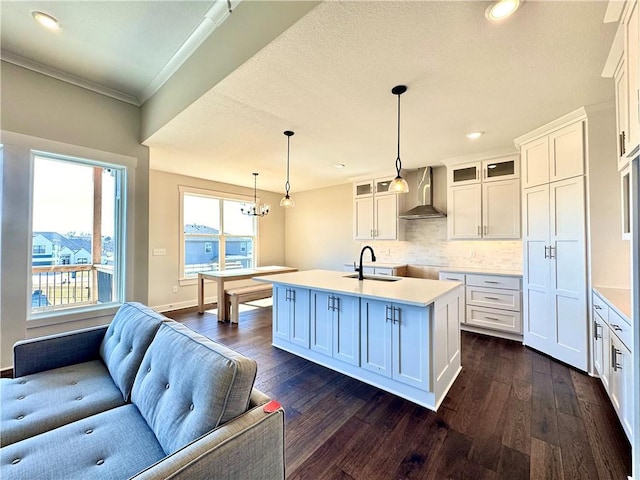 kitchen featuring backsplash, glass insert cabinets, wall chimney range hood, dark wood finished floors, and white cabinets