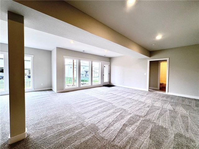 carpeted empty room featuring baseboards