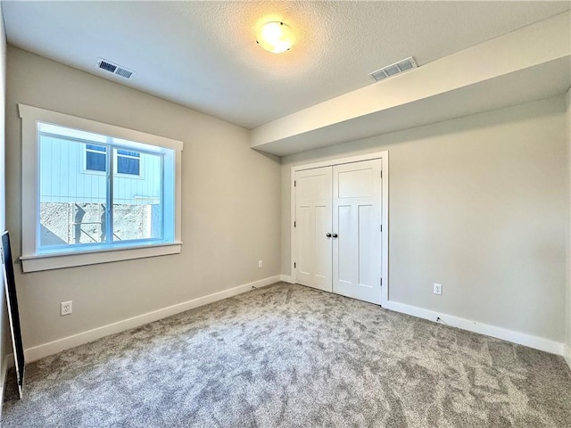 unfurnished bedroom with visible vents, carpet flooring, and baseboards