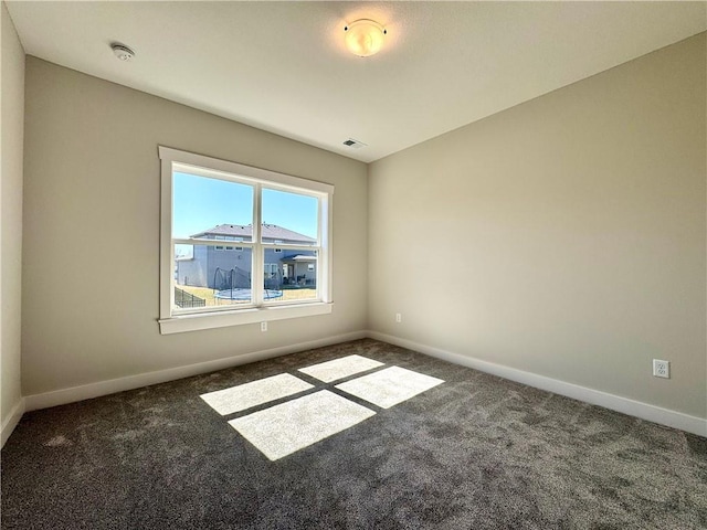 spare room featuring visible vents, baseboards, and carpet