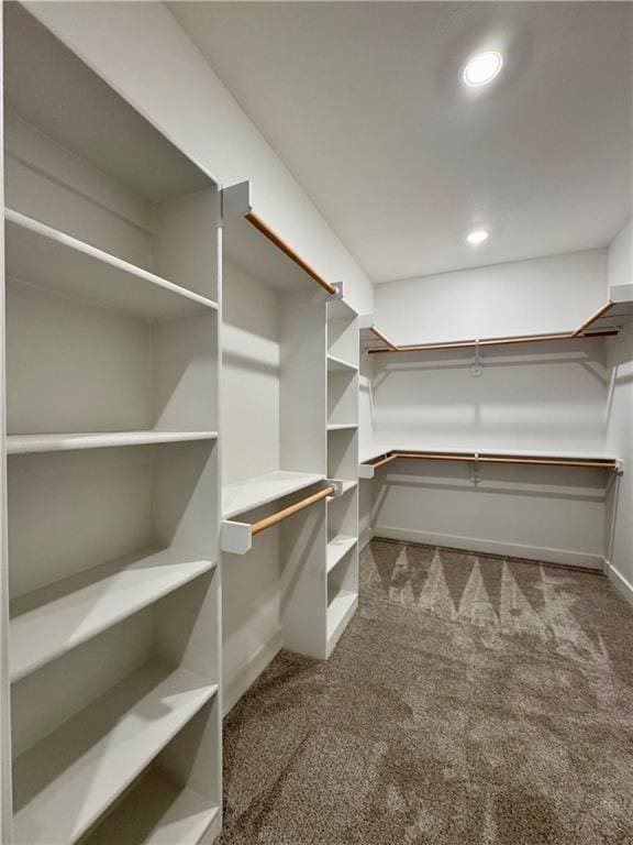 walk in closet featuring dark colored carpet