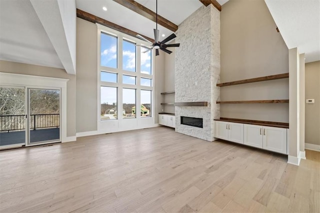 unfurnished living room featuring a wealth of natural light, high vaulted ceiling, and light hardwood / wood-style floors