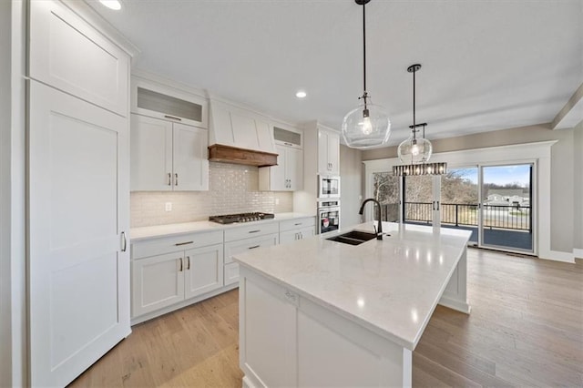 kitchen with sink, white cabinets, an island with sink, and appliances with stainless steel finishes