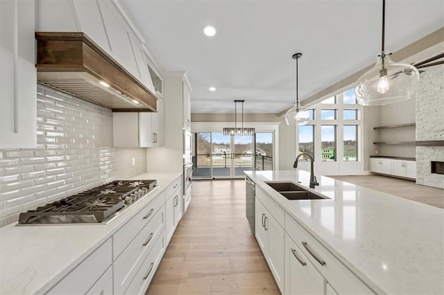 kitchen with sink, white cabinets, stainless steel appliances, and light hardwood / wood-style flooring